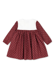 Red polka dot dress with white collar on a white background