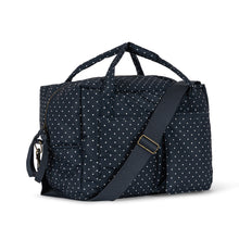 將圖片載入圖庫檢視器 A navy blue duffel bag with a white polka dot pattern, featuring dual top handles, a detachable shoulder strap, and a zippered side pocket, shown against a plain white background.