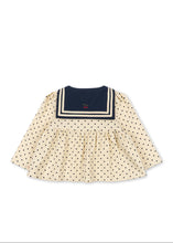 Load image into Gallery viewer, A cream-colored long-sleeve baby dress with black polka dots and a navy blue sailor collar with cream trim, shown flat on a white background.