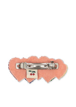 Load image into Gallery viewer, A heart-shaped pink felt hair pin with a silver metal clasp and a small embroidered cherry patch in the center, shown against a plain white background.