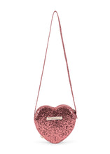 Load image into Gallery viewer, A small, heart-shaped pink glitter shoulder bag with a thin matching pink strap and a small silver metal logo plaque on the front, set against a plain white background.