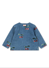 Load image into Gallery viewer, A blue denim long-sleeve top with an all-over cherry print, laid flat against a solid white background.