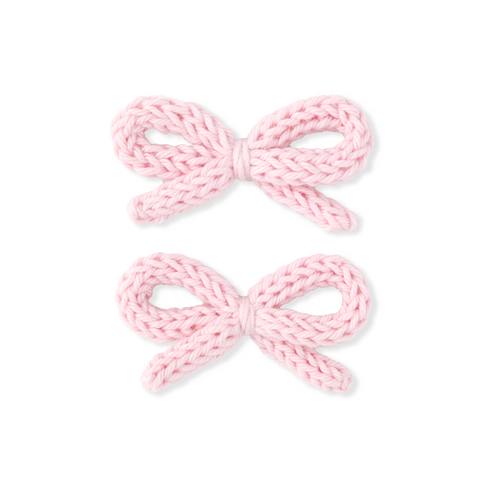 Two pink knitted bows on a white background