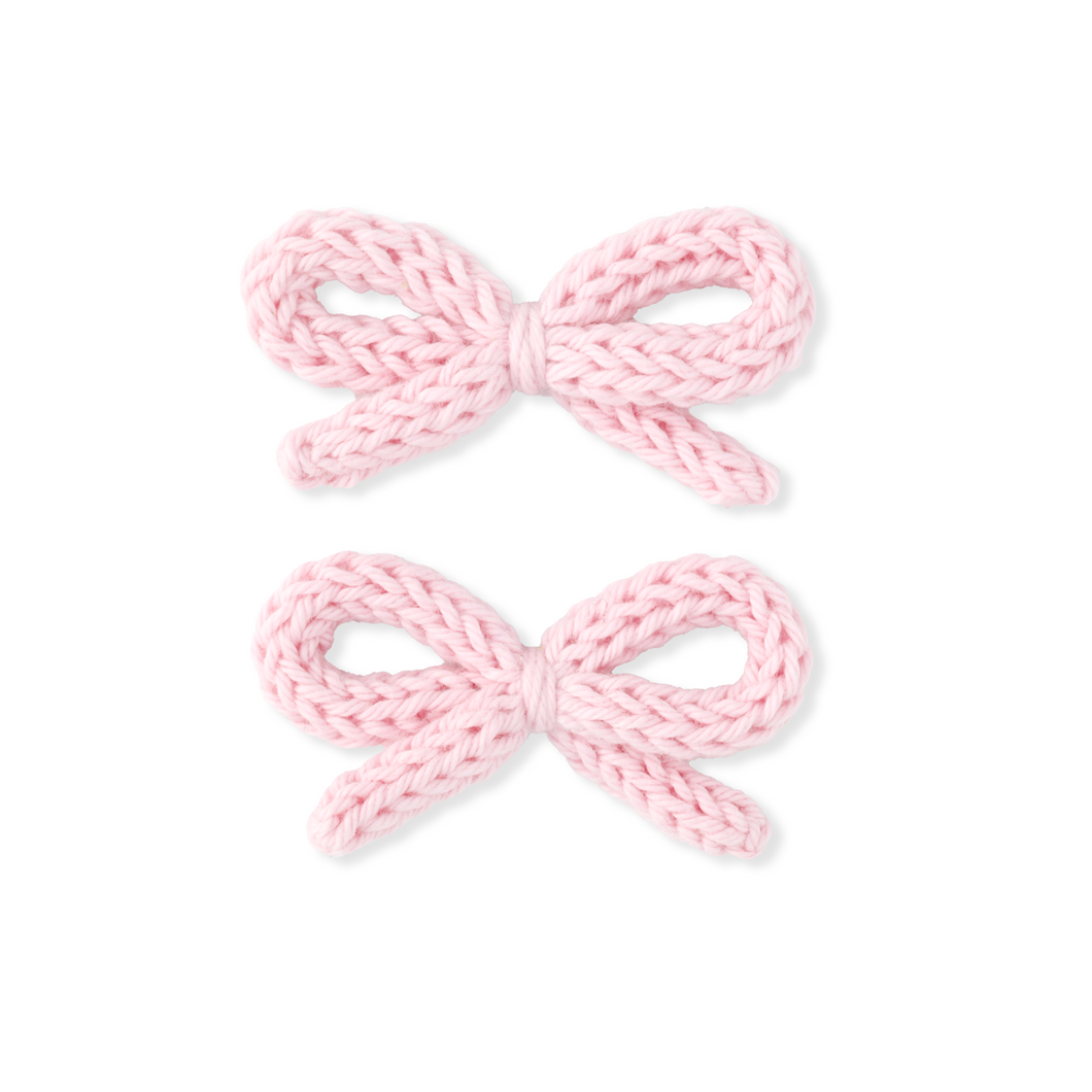 Two pink knitted bows on a white background