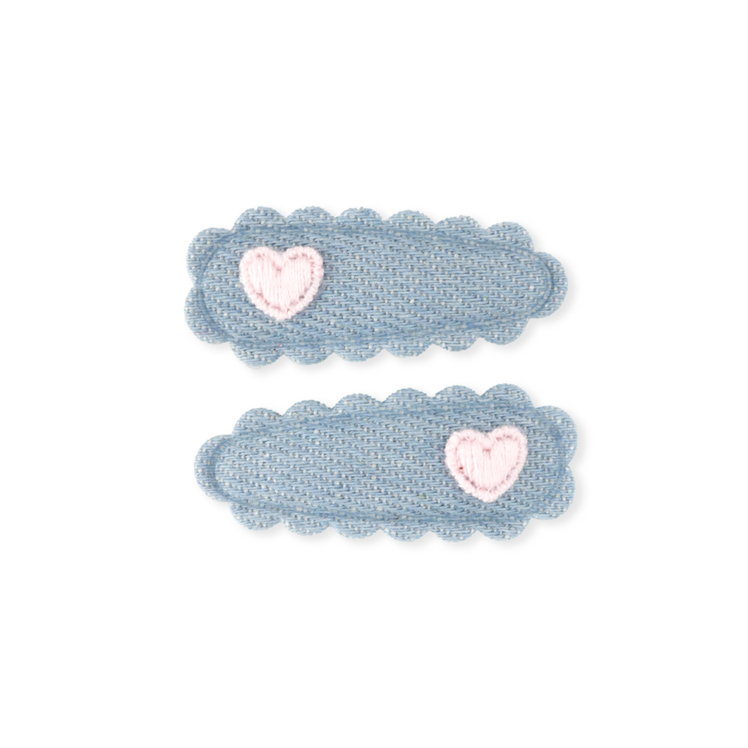 Two blue hair clips with pink hearts on a white background